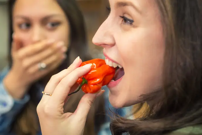 Is she crazy for taking a bite off the red-hot pepper? No, she’s just Mexican, adventurous and living life on the edge!
